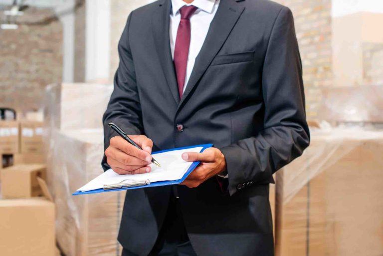 Makler hält Wohnungsübergabeprotokoll in Händen